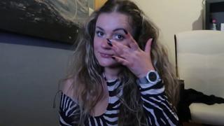 Thick blonde girl blows hot kiss, offering you a lit cigarrette